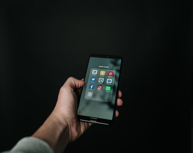 person%20holding%20iPhone%20with%20social%20media%20apps%20on%20screen person%20holding%20iPhone%20with%20social%20media%20apps%20on%20screen